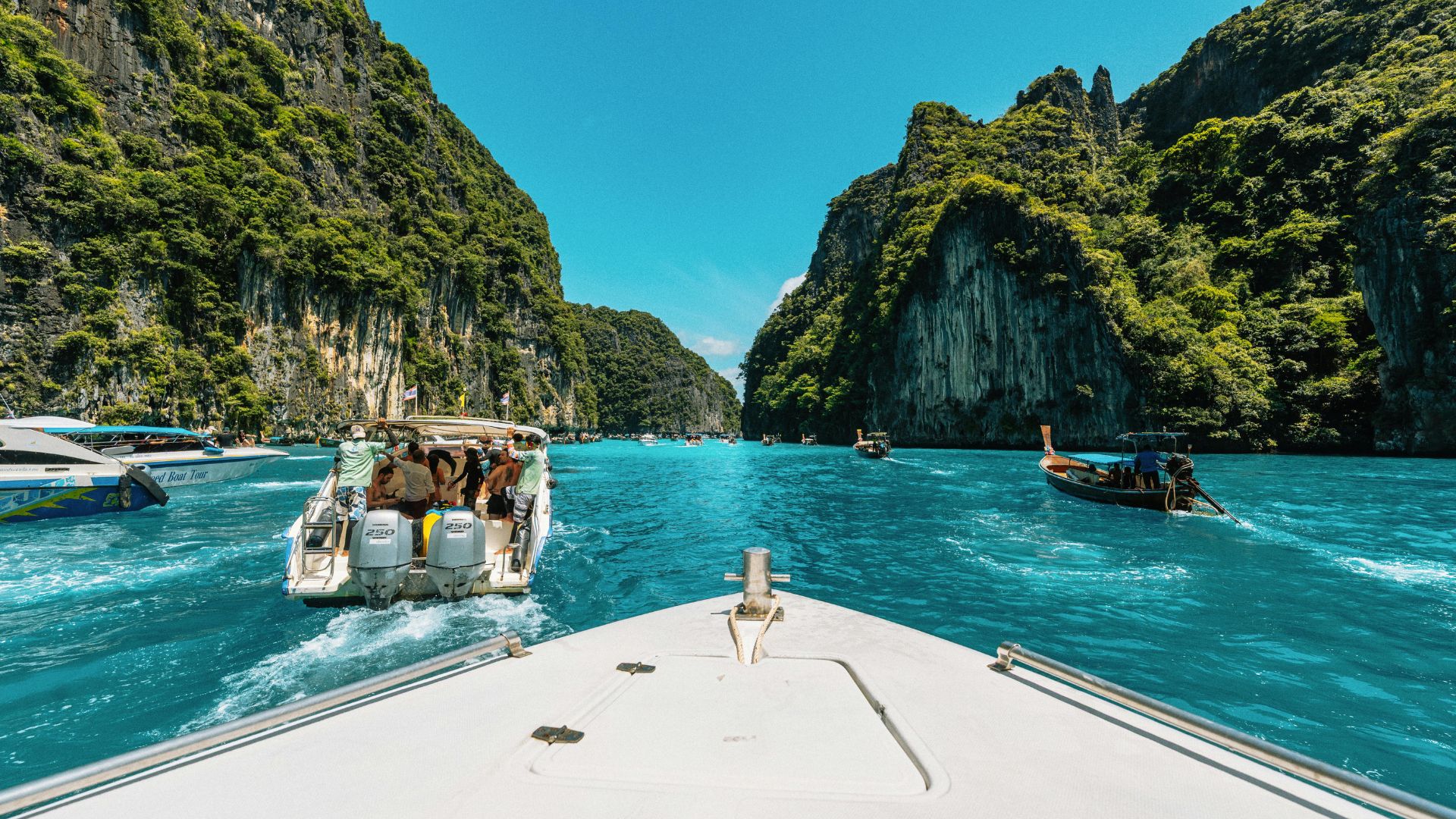 Boats in a turquoise lagoon between limestone cliffs, Thailand